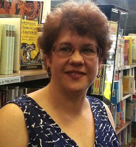 kathryn west smiles in front of book shelves