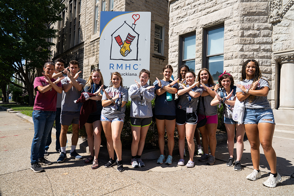 Students do the Swords Up pose outside of Ronald McDonald House Charities