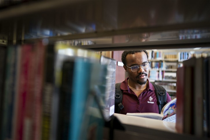 A Bellarmine University student reads a book in the library.