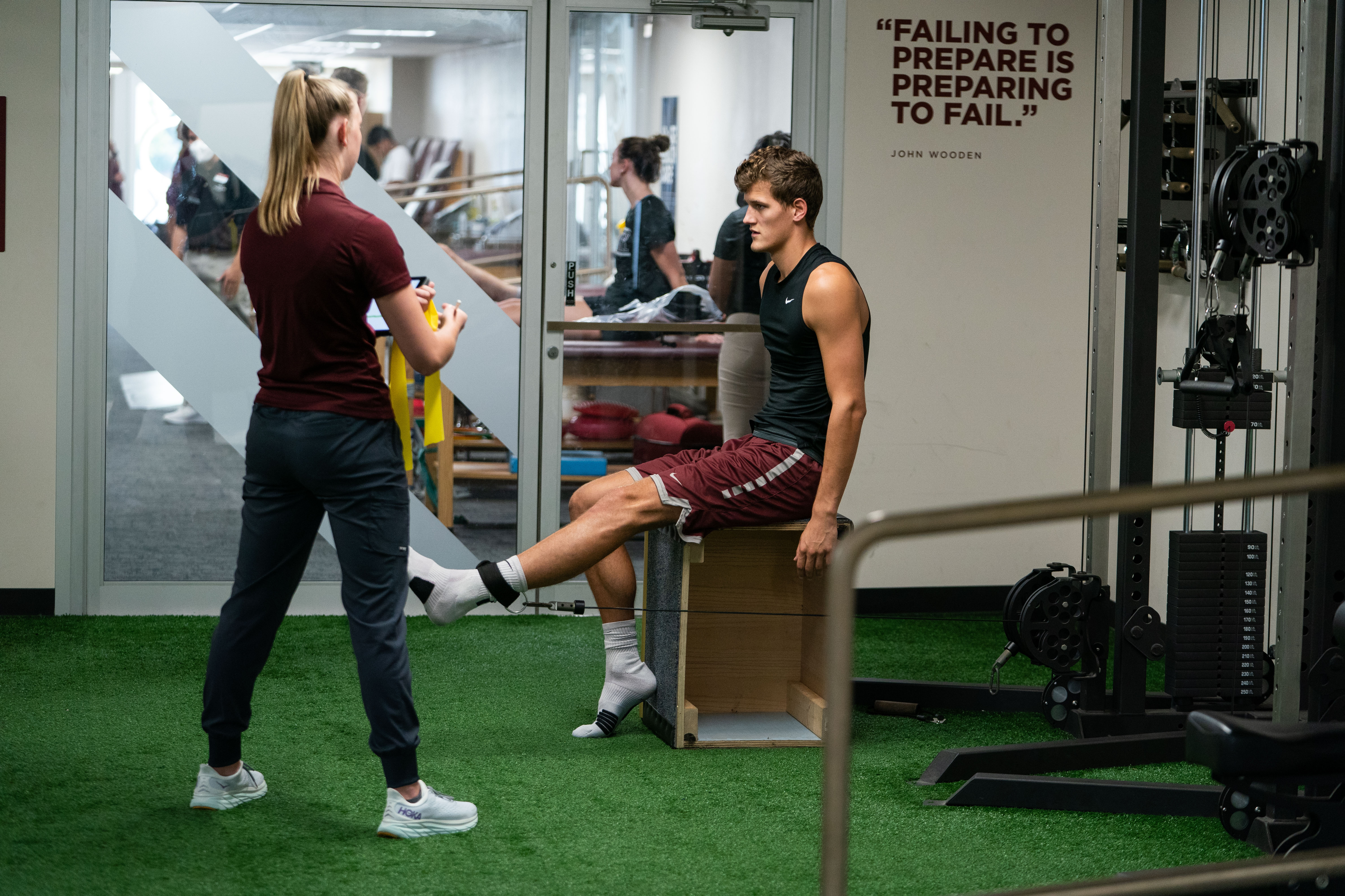 A clinic worker leads a patient through an exercise.