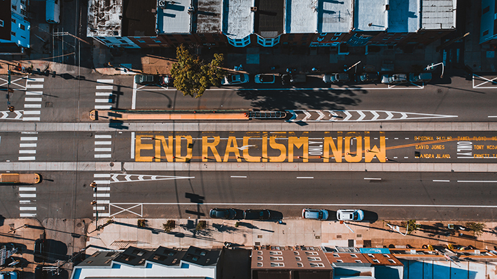 Overhead photo with "END RACISM NOW" painted on a street