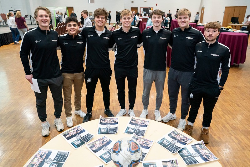 a group of student athletes pose for a group photo at an award ceremony