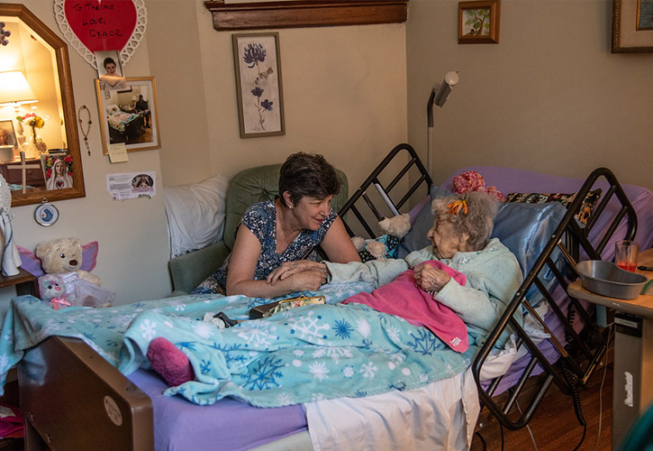 Karen Cassidy bedside with a Hildegard House resident