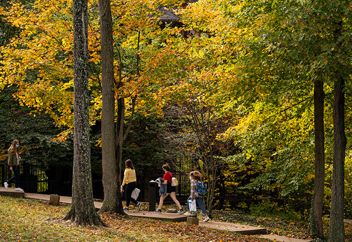 Students walk through Bellarmine's campus under an autumnal canopy.