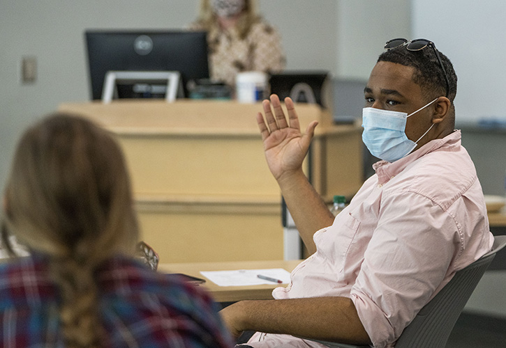 SGA president Trey Grevious wearing a face mask and waving