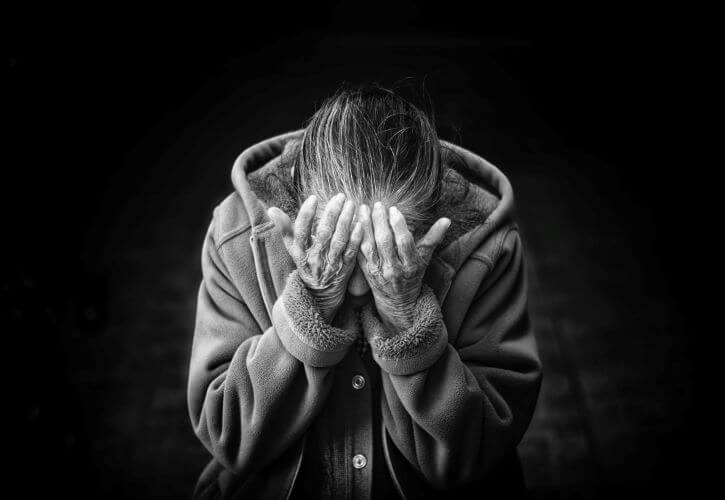 Woman holds her head in grief. Cristian Newman for Unsplash