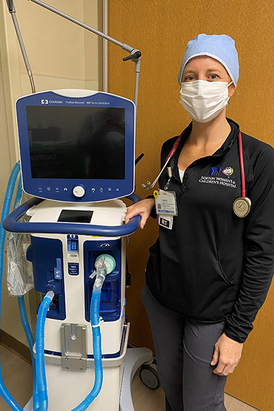 Lauren Jones stands next to a respirator
