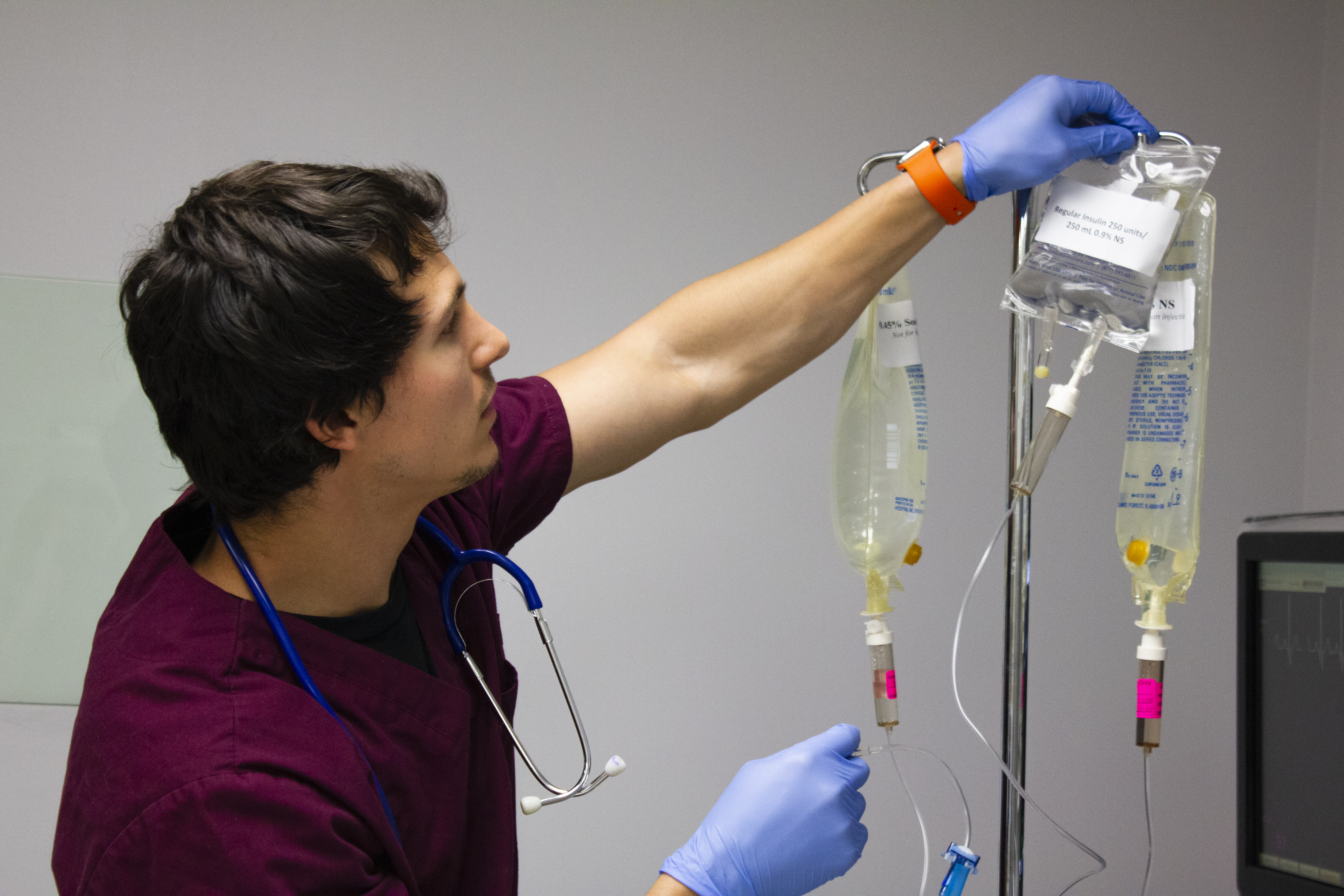 Nursing student hangs an IV bag