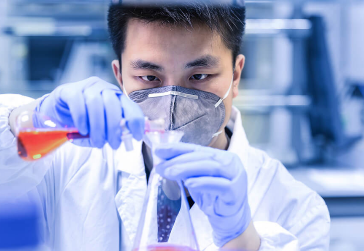 Medical professional pours chemicals into a vial