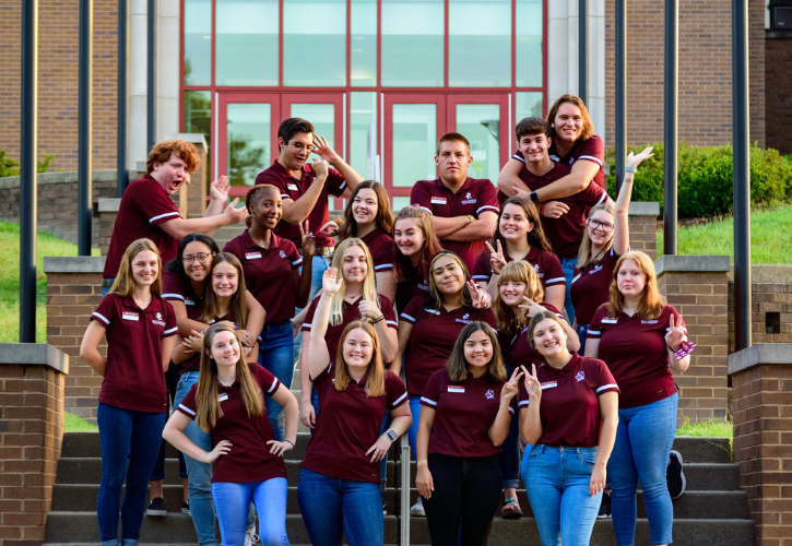 Bellarmine Ambassadors wave at you standing in front of Centro