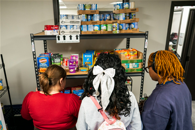 Students browse shelves full of food in the Knight's Pantry