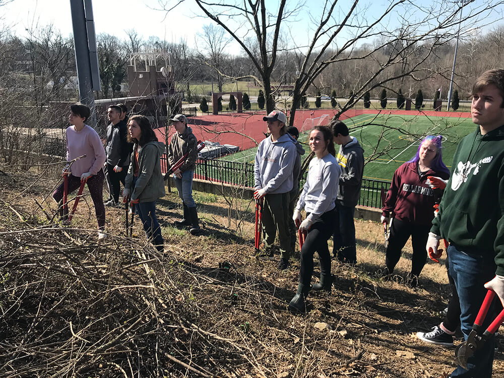 Students standing in a forested area at Bellarmine