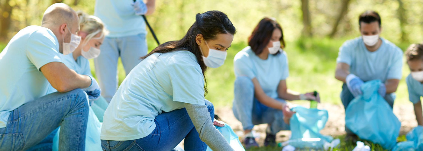 a group of volunteers help clean up litter in a park