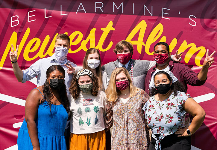 Students in front of a banner that reads Bellarmine's Newest Alum