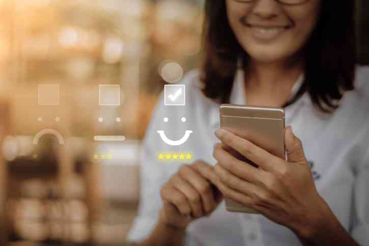 Stock image of woman giving a 5-star rating on her phone 