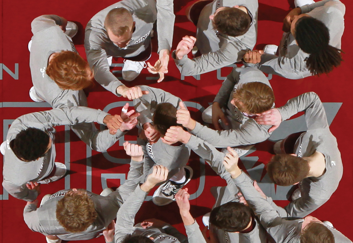 Men's basketball team in a huddle 