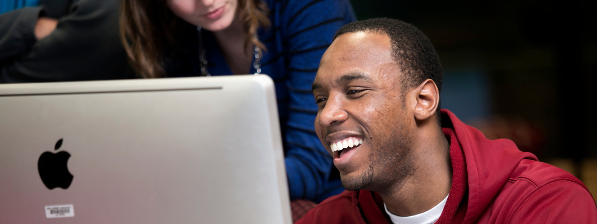 Student gleams joyfully at a computer screen