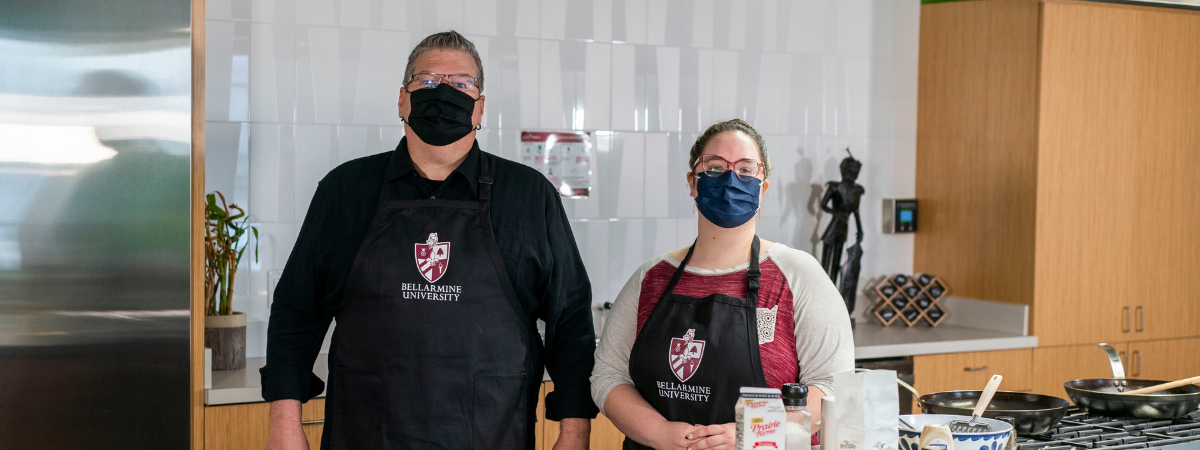 Nutrition instructors with bellarmine aprons pose in a kitchen