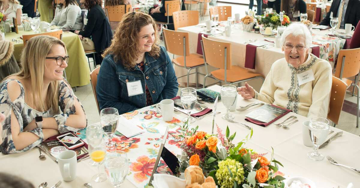Jayne BecVar, right, chats with student scholarship recipients at the 2018 Heritage Society Brunch. 
