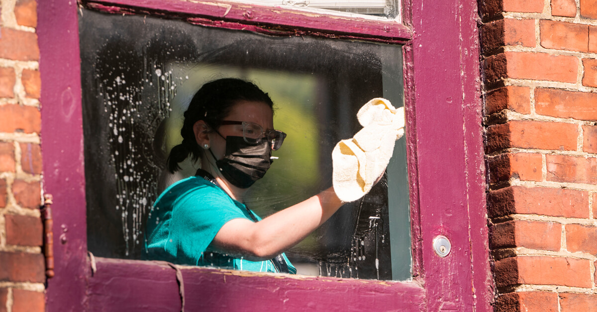 Student volunteer cleans window