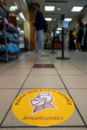 Stickers on the floor remind students to keep at least 6 feet apart in common areas.