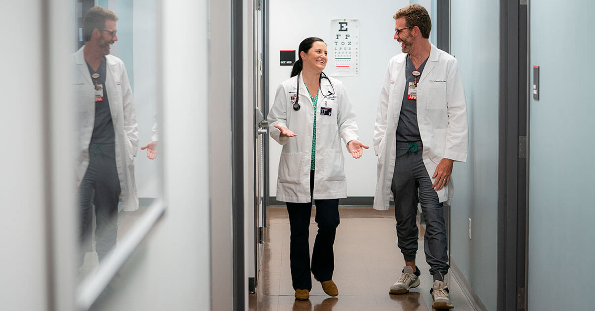 Bellarmine healthcare graduates walk in hallway in medical setting