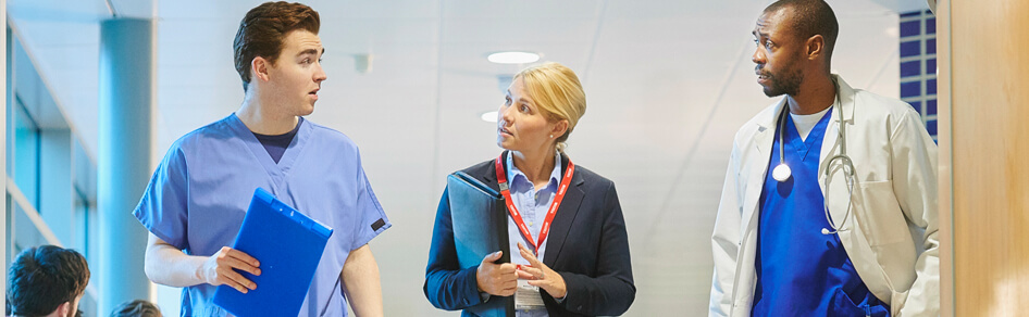 Professional woman walking with nurse and doctor