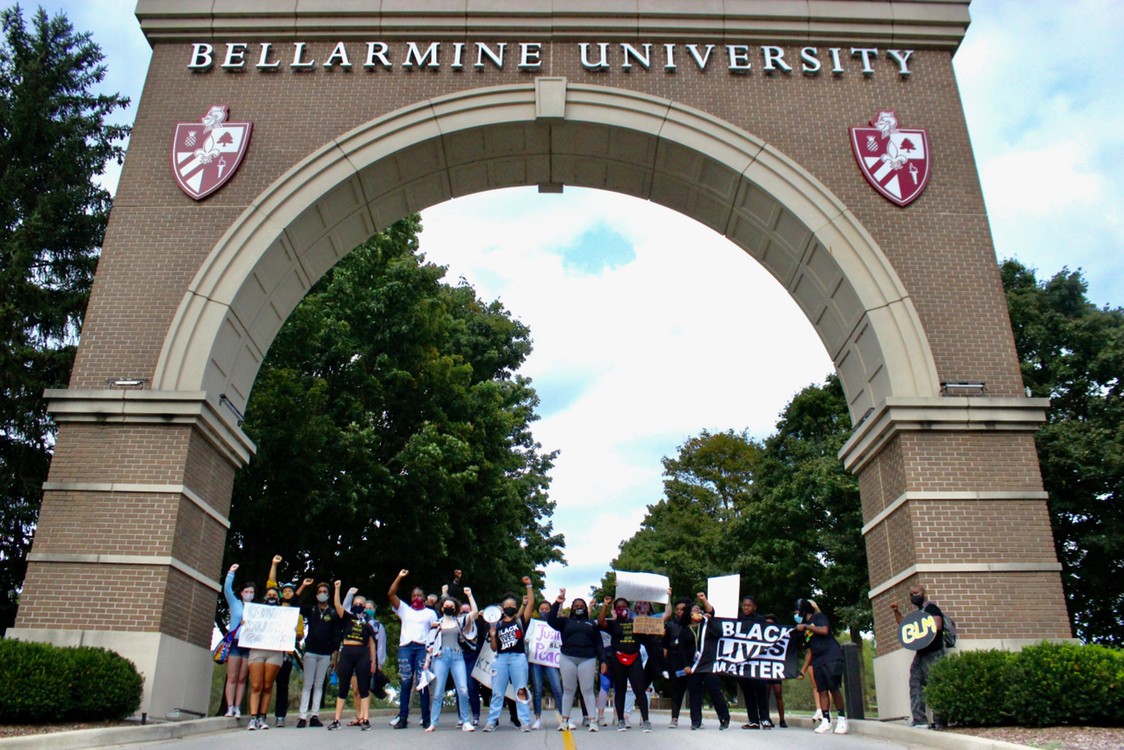 Students posing under Bellarmine University arch