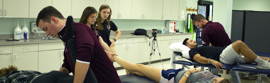 Physical therapy students treat patients in a classroom
